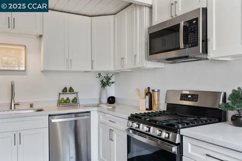 a kitchen with stainless steel appliances a stove a microwave and sink