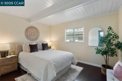 a bedroom with a bed and a potted plant