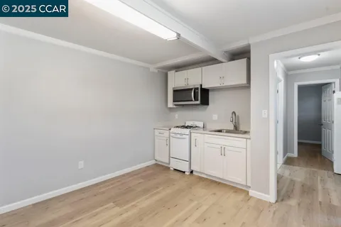 a kitchen with a sink cabinets and wooden floor