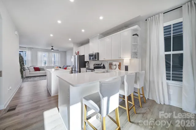 a kitchen with stainless steel appliances kitchen island granite countertop a refrigerator and cabinets
