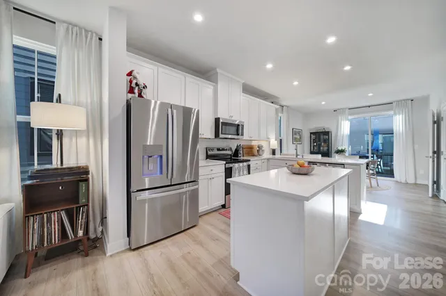 a kitchen with kitchen island a refrigerator and a stove top oven