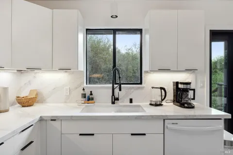 a kitchen with appliances a sink and a window