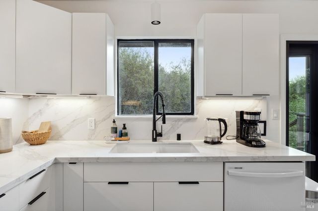 a kitchen with appliances a sink and a window