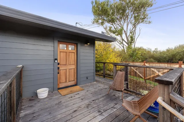 a balcony with wooden floor table and chairs