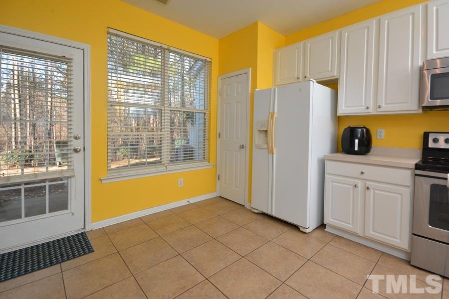 8249 City Loft Court Raleigh, NC 27613 - Photo 12 of 28 a view of a kitchen with white cabinets and a refrigerator