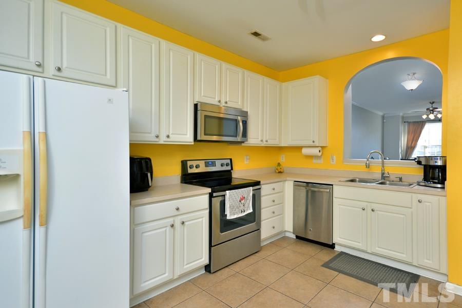 8249 City Loft Court Raleigh, NC 27613 - Photo 13 of 28 a kitchen with a sink and white cabinets