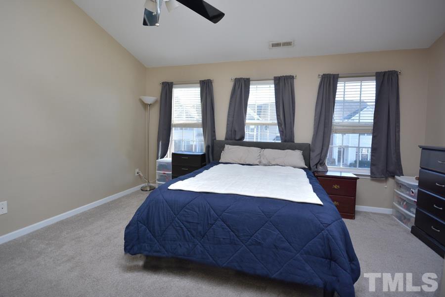 8249 City Loft Court Raleigh, NC 27613 - Photo 20 of 28 a bedroom with a bed a flat screen tv and window