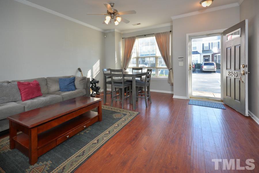 8249 City Loft Court Raleigh, NC 27613 - Photo 2 of 28 a living room with furniture a wooden floor and a large window