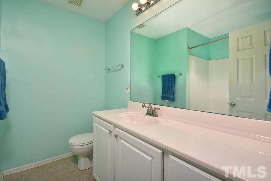 8249 City Loft Court Raleigh, NC 27613 - Photo 22 of 28 a bathroom with a sink a toilet and shower