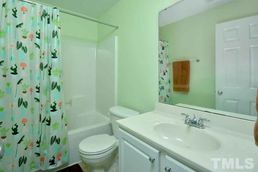 8249 City Loft Court Raleigh, NC 27613 - Photo 25 of 28 a bathroom with a sink a toilet and shower curtain