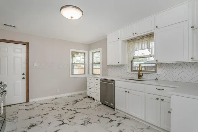 a kitchen with stainless steel appliances wooden floor and a sink