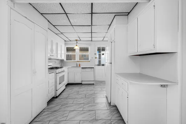 a kitchen with white cabinets and white appliances