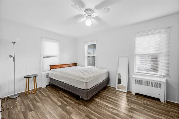 a spacious bedroom with a bed and ceiling fan