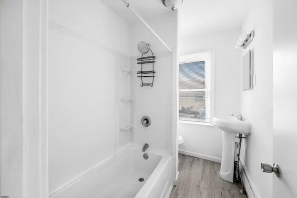 a bathroom with a bathtub a window and a shower