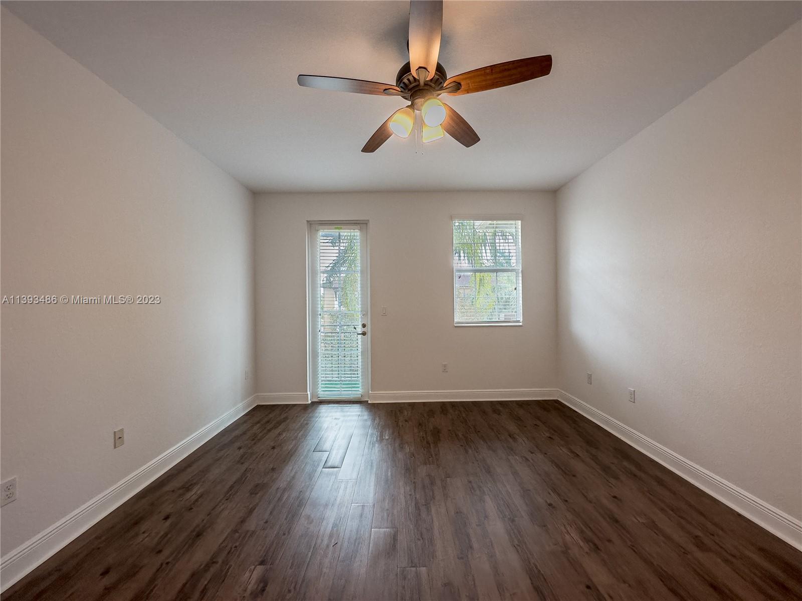 865 Southwest 147th Avenue, Unit 1908 Pembroke Pines, FL 33027 - Photo 15 of 30 an empty room with wooden floor fan and windows
