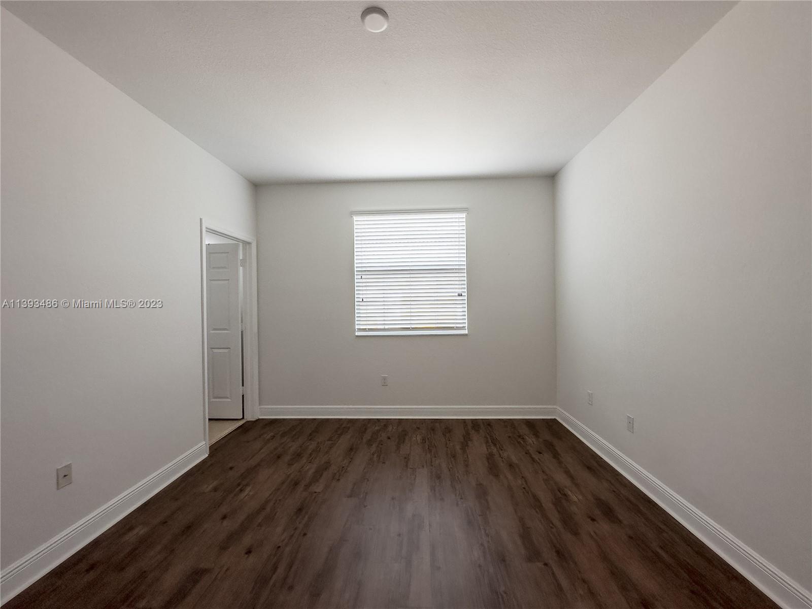 865 Southwest 147th Avenue, Unit 1908 Pembroke Pines, FL 33027 - Photo 23 of 30 an empty room with wooden floor and windows