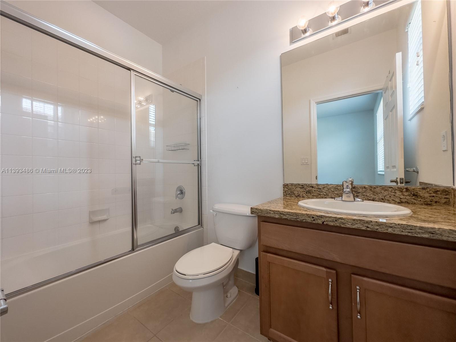 865 Southwest 147th Avenue, Unit 1908 Pembroke Pines, FL 33027 - Photo 26 of 30 a bathroom with a granite countertop sink toilet and shower
