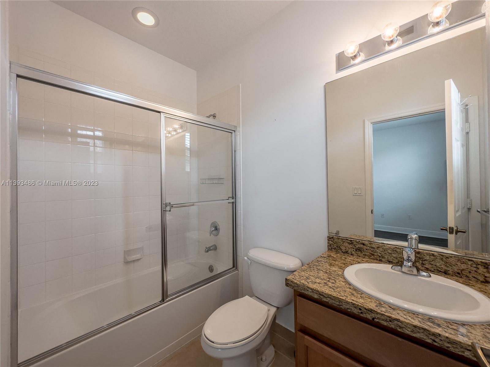 865 Southwest 147th Avenue, Unit 1908 Pembroke Pines, FL 33027 - Photo 27 of 30 a bathroom with a granite countertop sink toilet mirror and shower