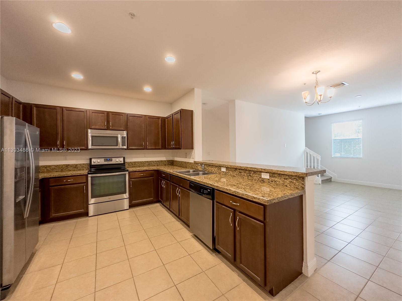 865 Southwest 147th Avenue, Unit 1908 Pembroke Pines, FL 33027 - Photo 6 of 30 a large kitchen with stainless steel appliances granite countertop a stove top oven a sink dishwasher and a refrigerator