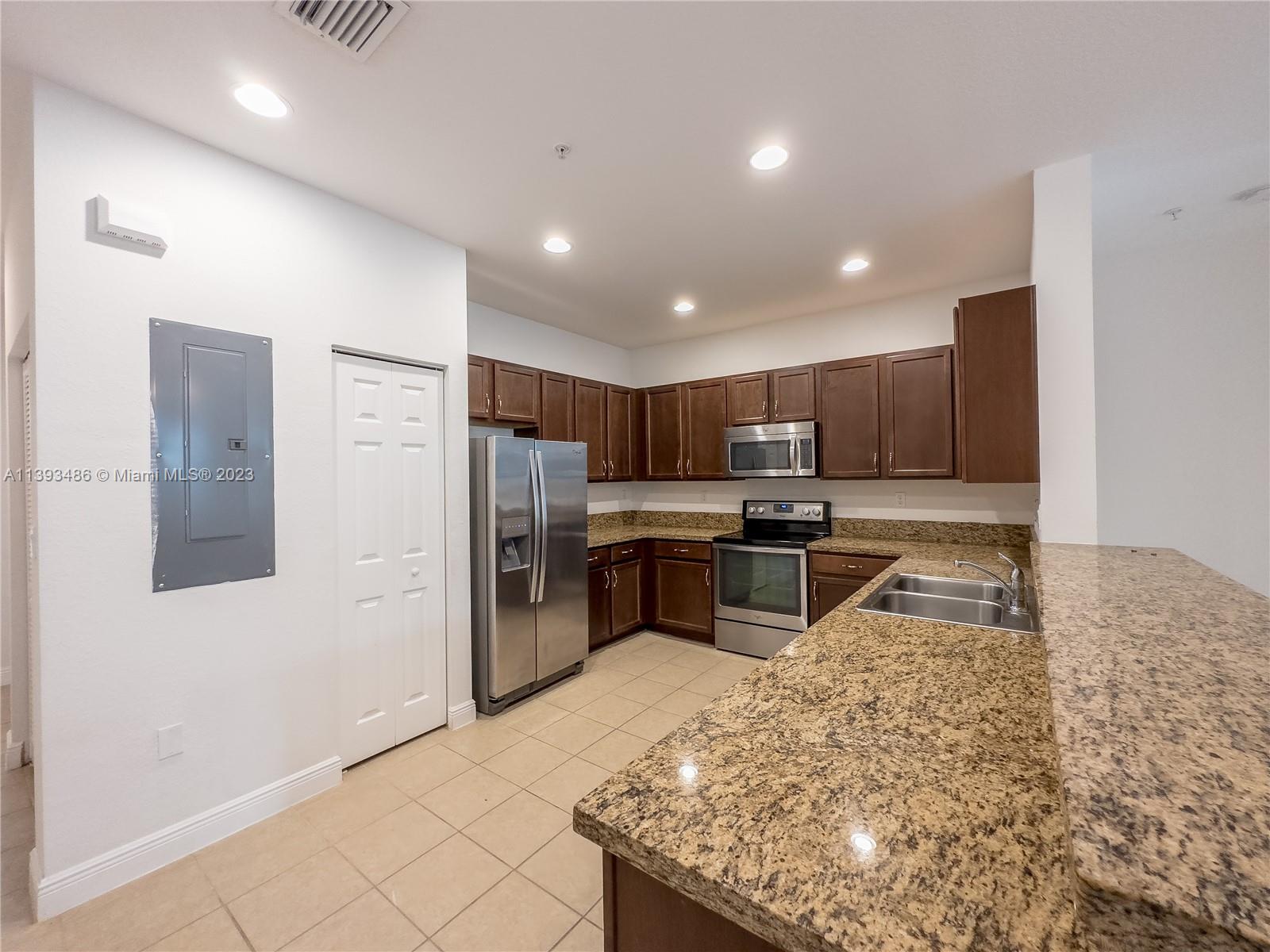865 Southwest 147th Avenue, Unit 1908 Pembroke Pines, FL 33027 - Photo 7 of 30 a kitchen with stainless steel appliances kitchen island granite countertop a refrigerator and a stove