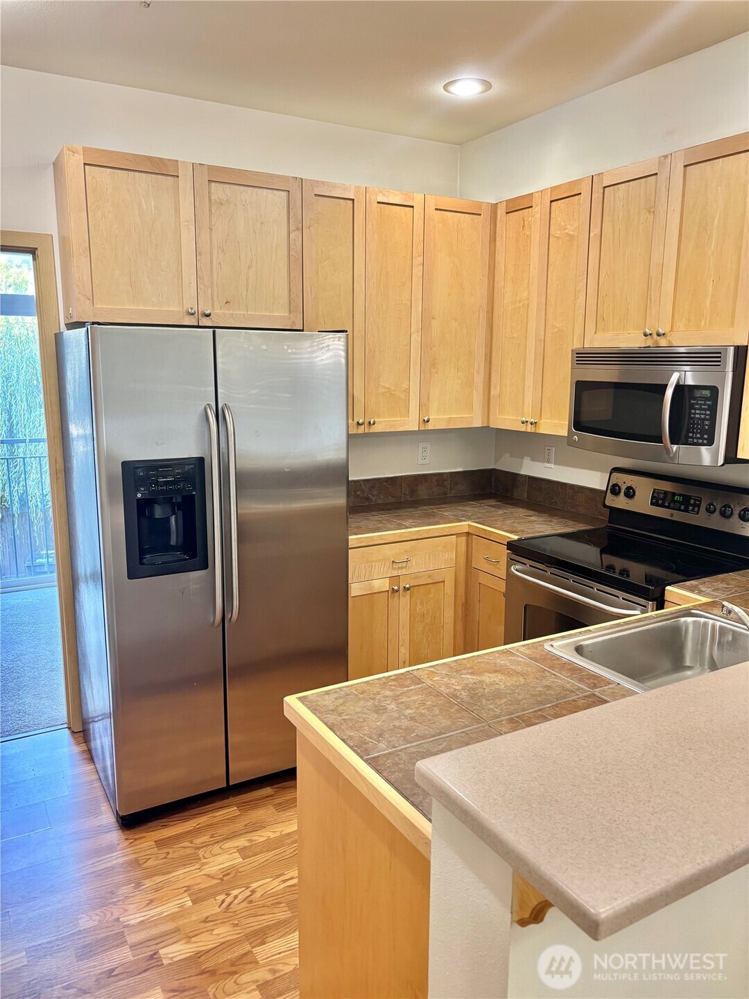 13005 64th Avenue South, Unit B117 Seattle, WA 98178 - Photo 11 of 37 a kitchen with kitchen island a counter top space a sink and a refrigerator