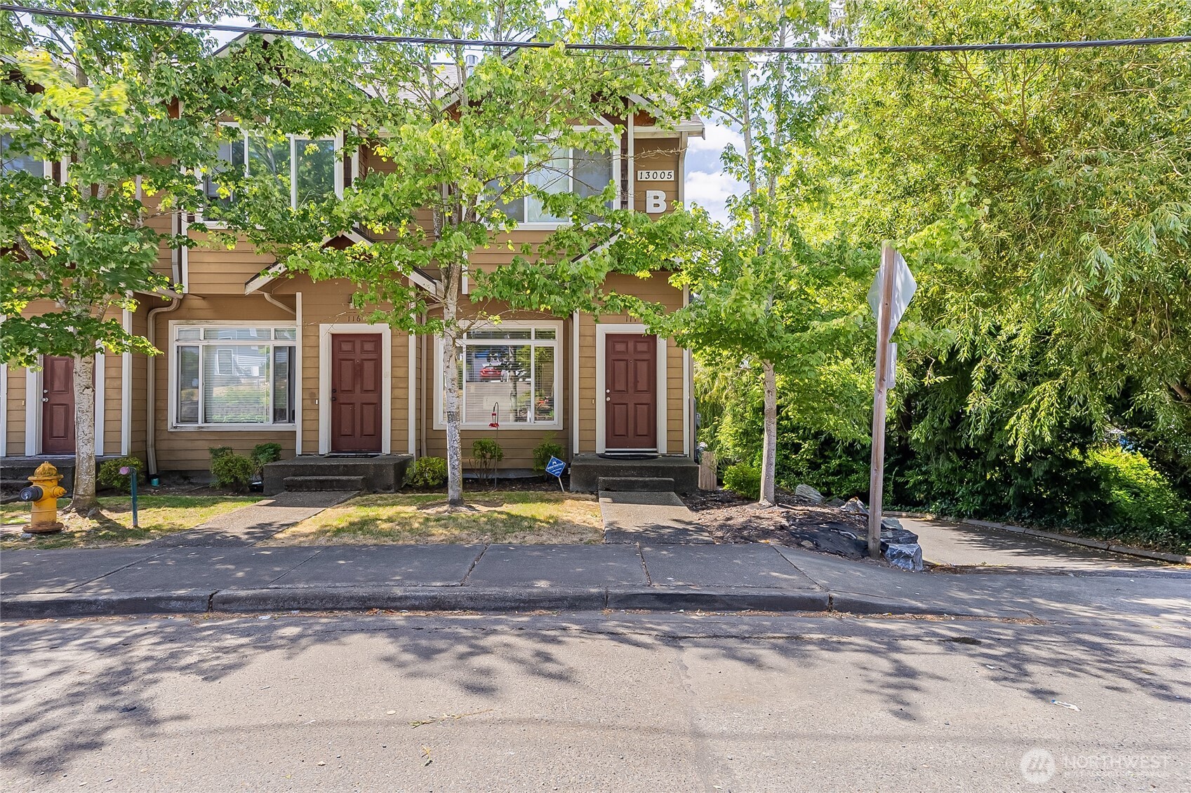 13005 64th Avenue South, Unit B117 Seattle, WA 98178 - Photo 2 of 37 a view of a brick house with large windows and a tree