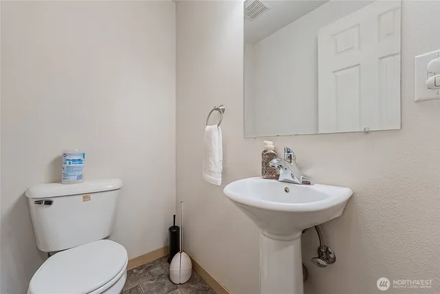 a bathroom with a toilet sink and mirror
