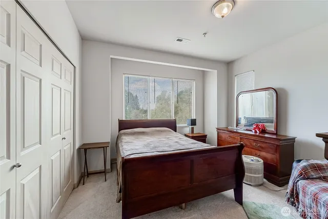 a room with a bed table chair and a window