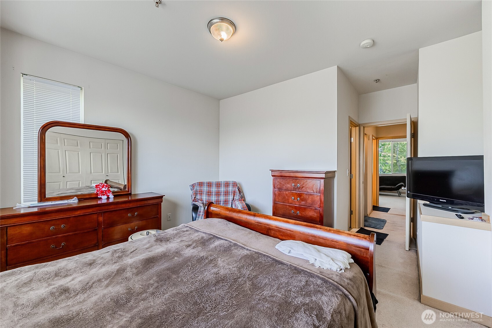 13005 64th Avenue South, Unit B117 Seattle, WA 98178 - Photo 28 of 37 a bedroom with a bed and a flat tv screen on dresser