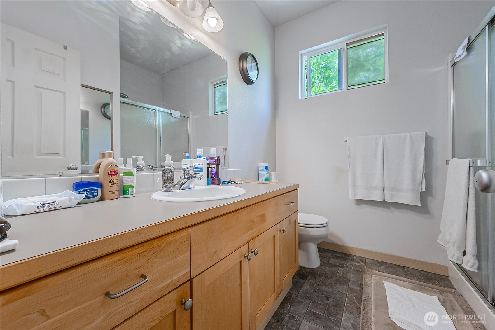 13005 64th Avenue South, Unit B117 Seattle, WA 98178 - Photo 30 of 37 a spacious bathroom with a double vanity sink a toilet and a mirror