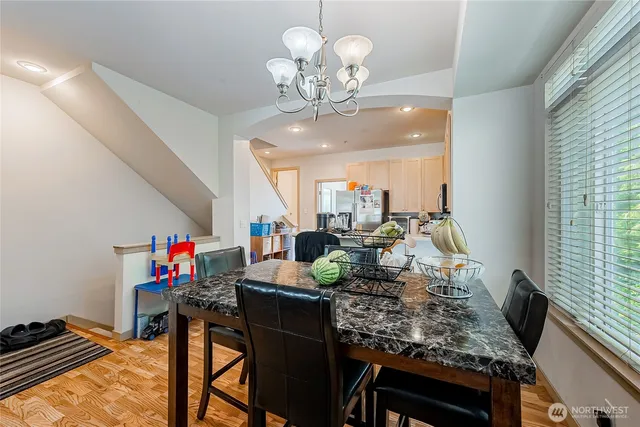 a view of a dining room with furniture a chandelier and a window