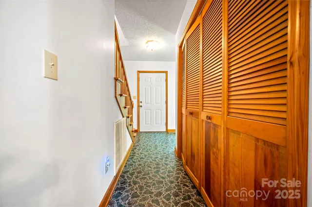 a view of a hallway with wooden floor and stairs