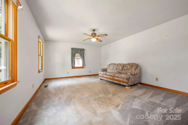 a living room with furniture and a ceiling fan