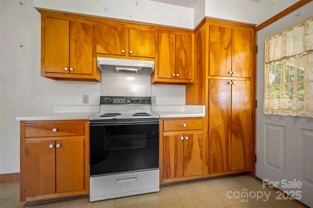 a kitchen with stainless steel appliances granite countertop wooden cabinets and a stove top oven