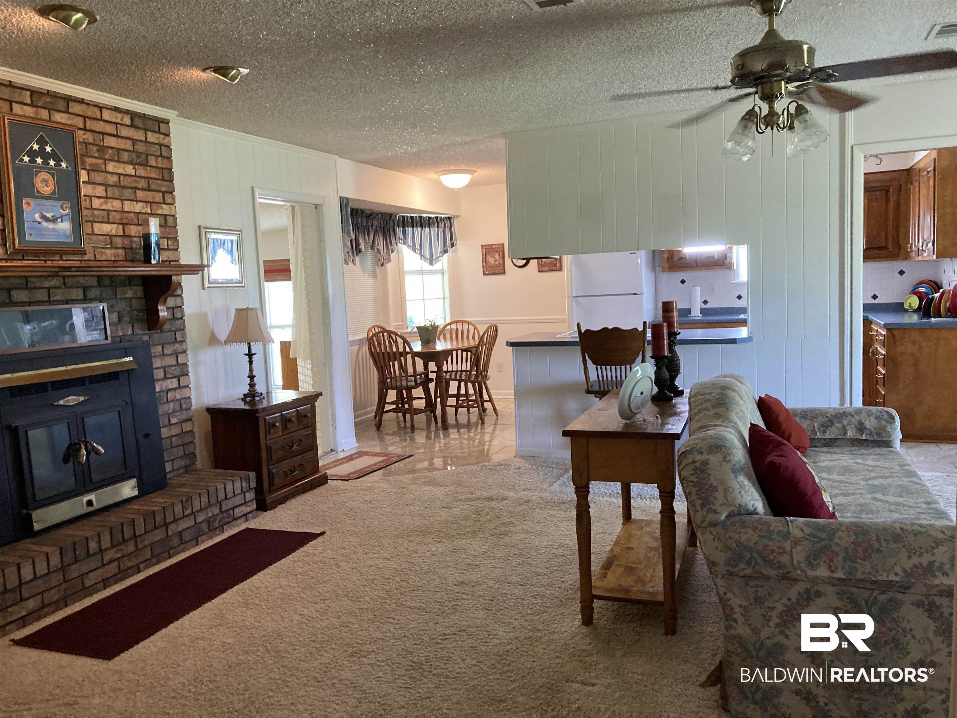 6151 Meadows Road Walnut Hill, FL 32568 - Photo 7 of 29 Living room featuring ceiling fan, light colored carpet, and a textured ceiling