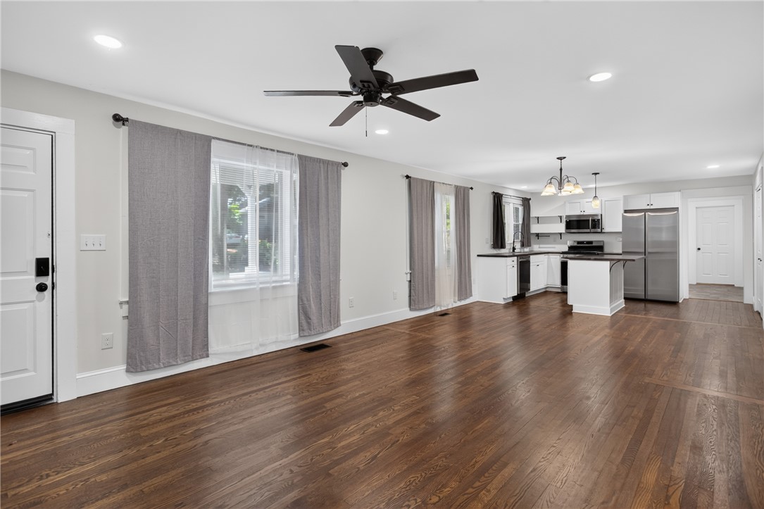 115 Pelfrey Street Seneca, SC 29672 - Photo 5 of 46 Rich hardwood floors unite an open-concept living space with a contemporary kitchen.