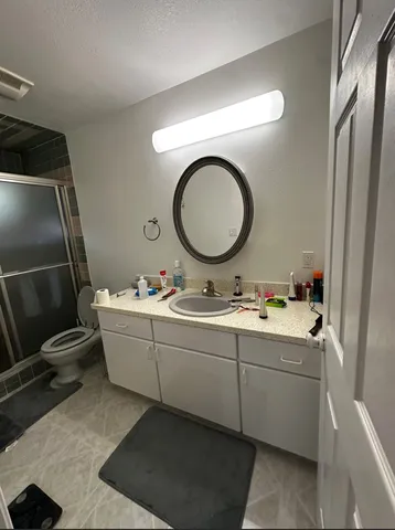a bathroom with a granite countertop sink and a mirror