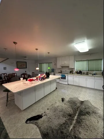 a living room with stainless steel appliances kitchen island furniture and a living room
