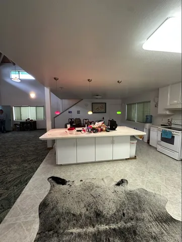 a living room with furniture kitchen view and a potted plant