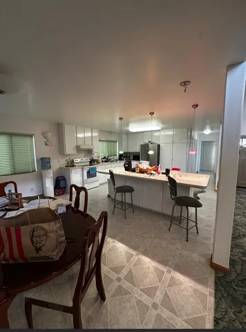 a living room with furniture and a dining table with kitchen view