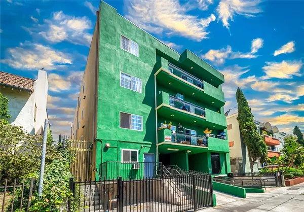 a front view of a multi story building with yard