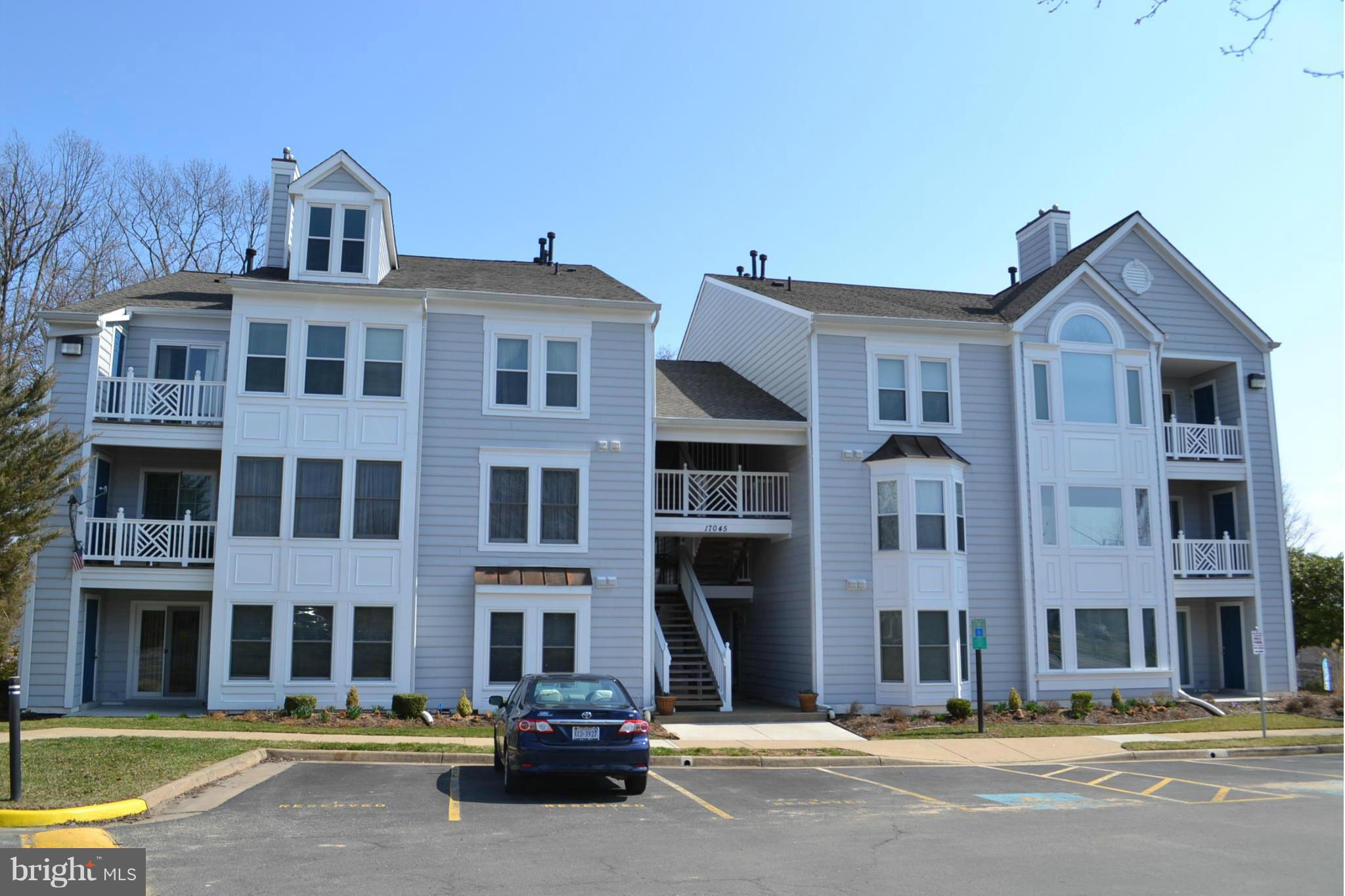 17045 Islip Loop, Unit 301 Dumfries, VA 22026 - Photo 1 of 14 a front view of a building with lot of cars and trees