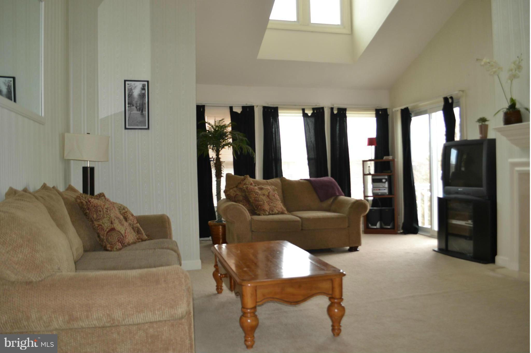 17045 Islip Loop, Unit 301 Dumfries, VA 22026 - Photo 5 of 14 a living room with furniture and a flat screen tv