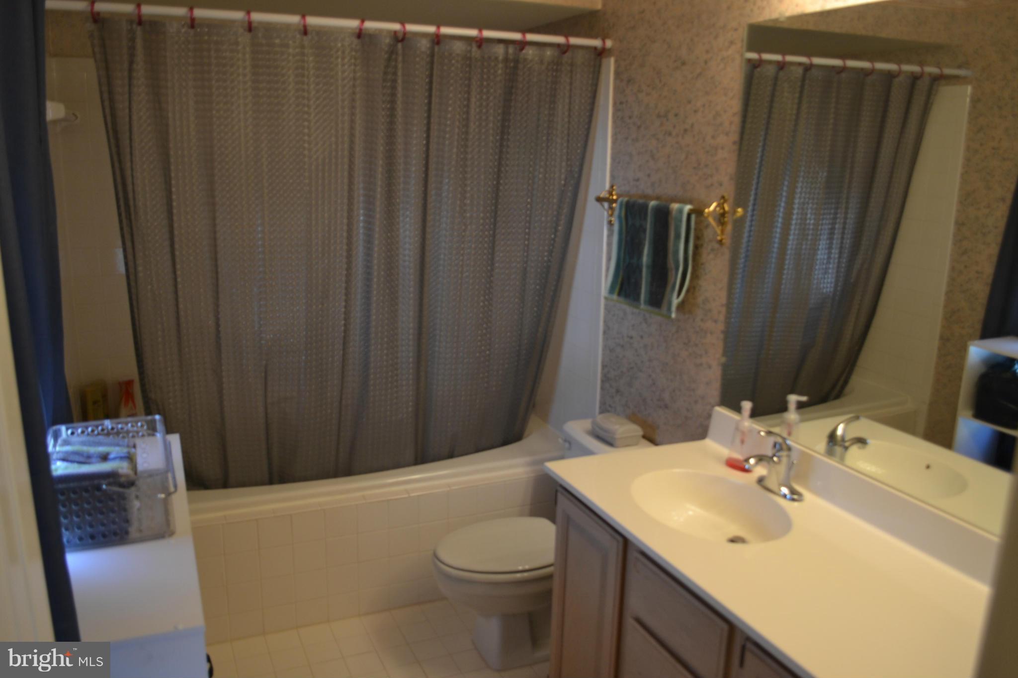 17045 Islip Loop, Unit 301 Dumfries, VA 22026 - Photo 7 of 14 a bathroom with a sink a toilet and shower