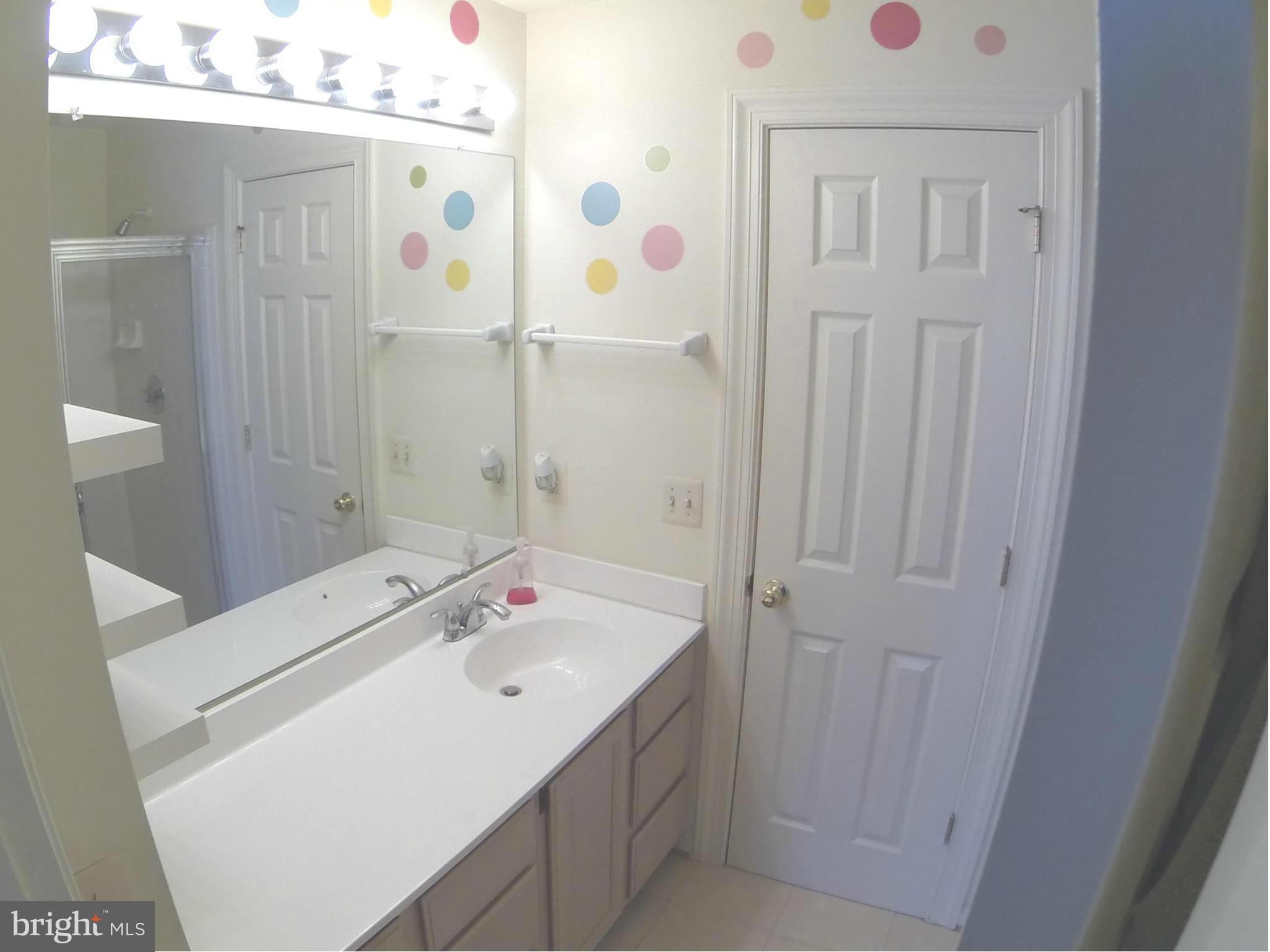 17045 Islip Loop, Unit 301 Dumfries, VA 22026 - Photo 10 of 14 a bathroom with a sink vanity and a mirror