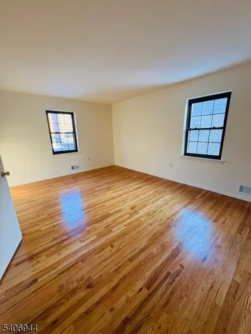 a view of a room with wooden floor and window