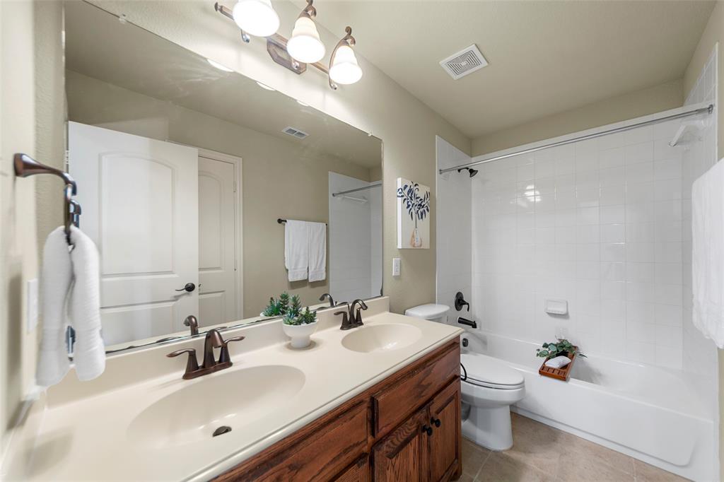 5143 Stream Crest Way Fairview, TX 75069 - Photo 29 of 35 Bathroom featuring double vanity, shower / bathtub combination, and light tile patterned floors