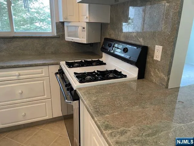 a kitchen with stainless steel appliances granite countertop a stove and a refrigerator