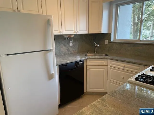 a kitchen with a white cabinets and a refrigerator