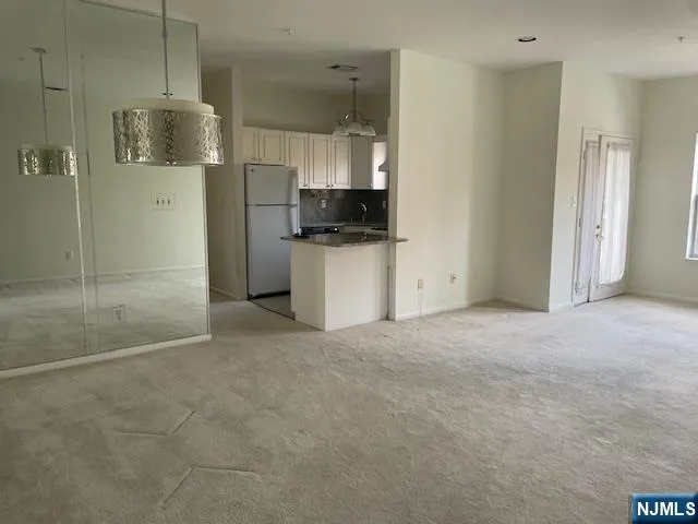 a view of a kitchen with a refrigerator and a sink